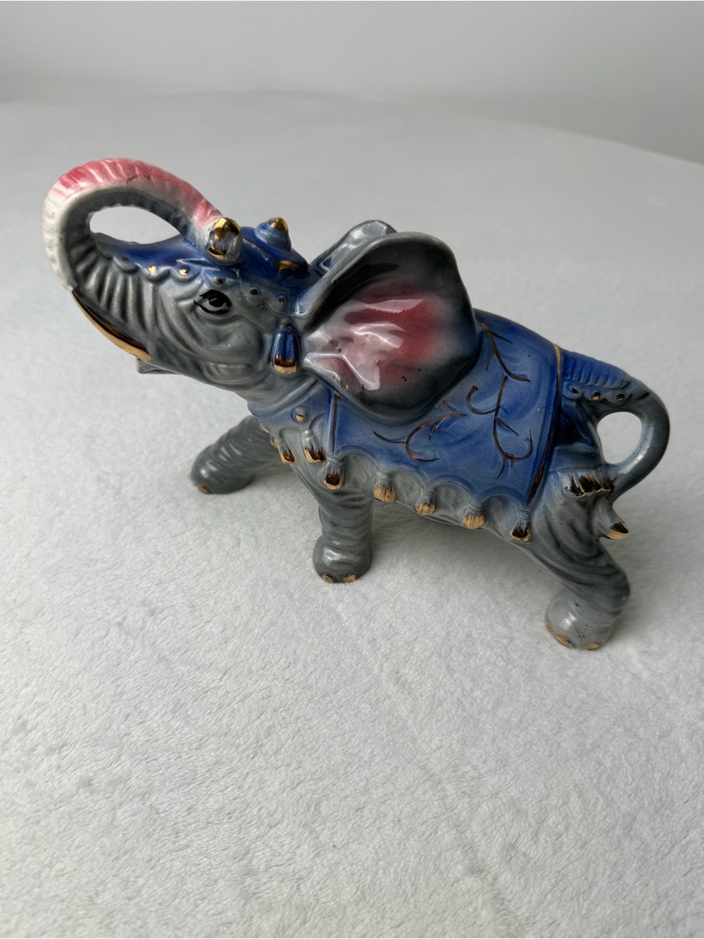 vintage ceramic circus elephant figurine with blue gray glaze and gold accents.